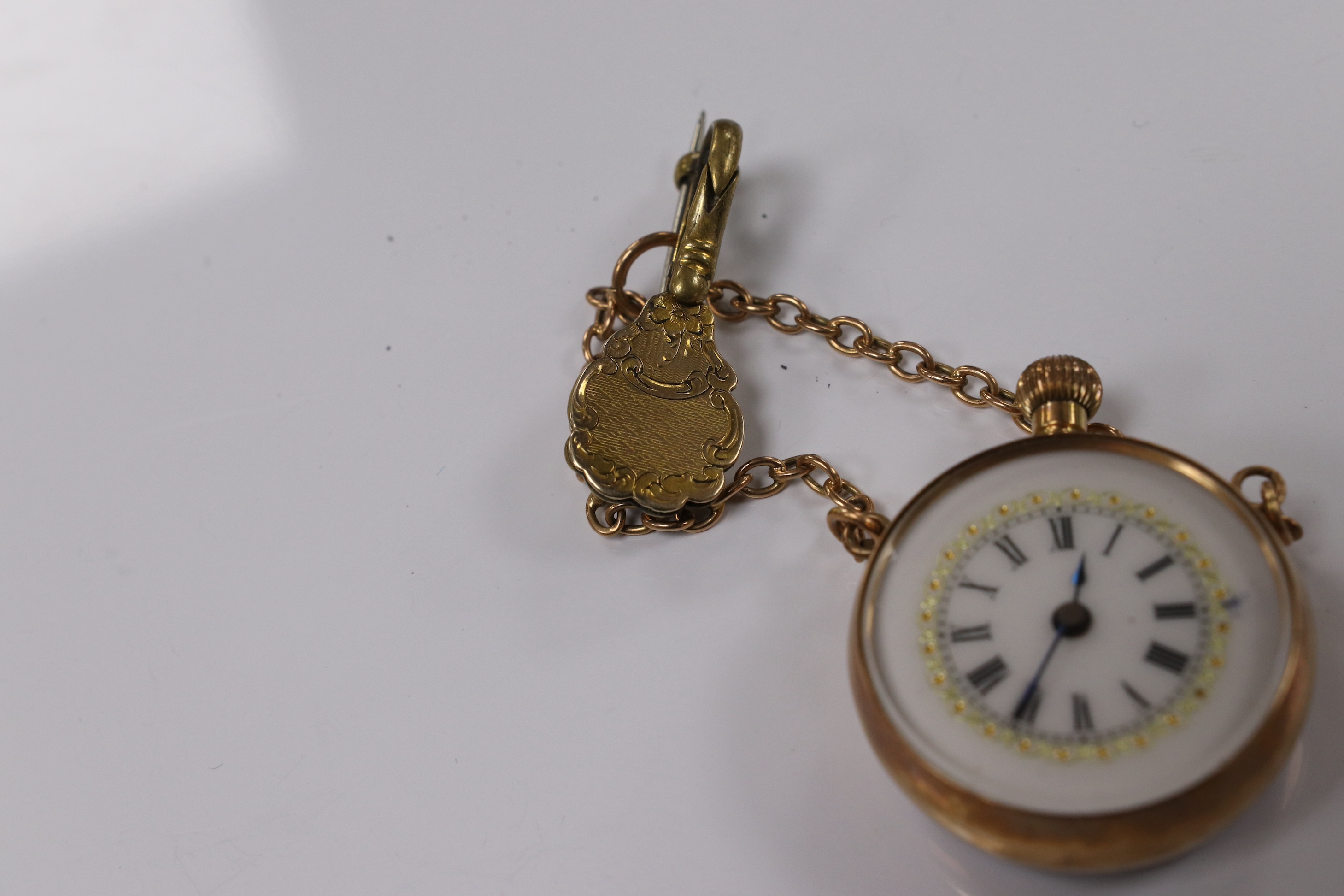 A lady's yellow metal mounted fob watch, with Roman dial and suspension chain with brooch, case diameter 26mm. Condition - fair